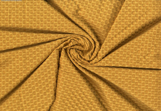 Stretch knit fabric featuring a raised honeycomb pattern with a structured, textured jacquard weave MUSTARD