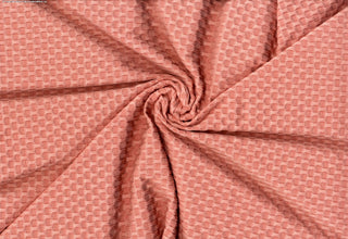 Stretch knit fabric featuring a raised honeycomb pattern with a structured, textured jacquard weave SALMON