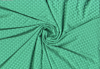 Stretch knit fabric featuring a raised honeycomb pattern with a structured, textured jacquard weave PARIS GREEN